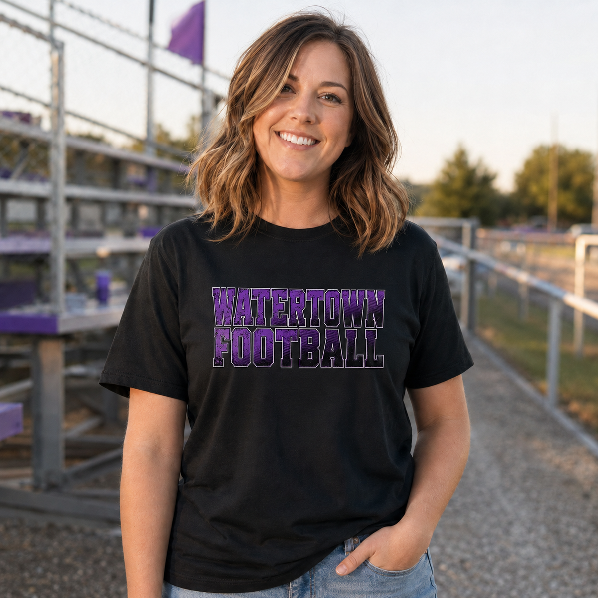Woman wearing a black Watertown Football graphic tee with a natural-sized front design